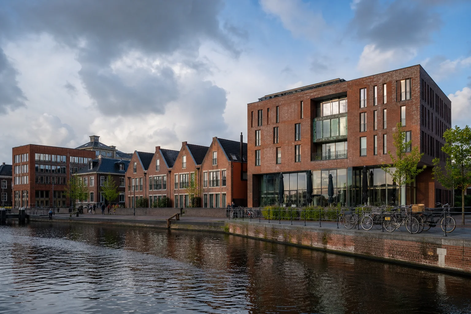 Nederlands stedelijk water met baksteenarchitectuur, fietsen en een wisselende lucht